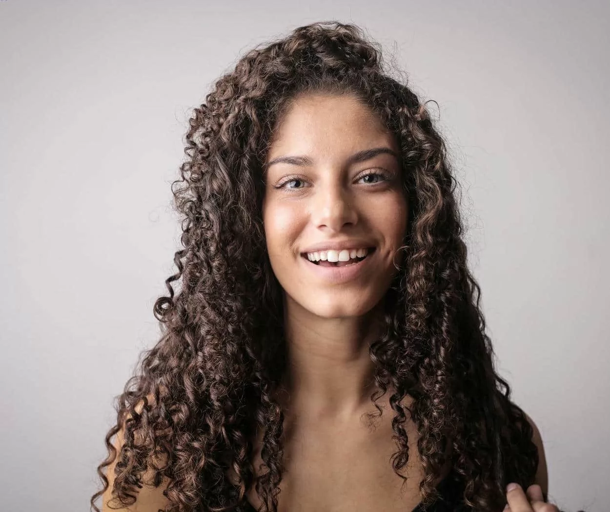 femme souriante aux cheveux frisés